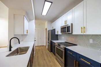 A kitchen with white cabinets and a black stove top oven.